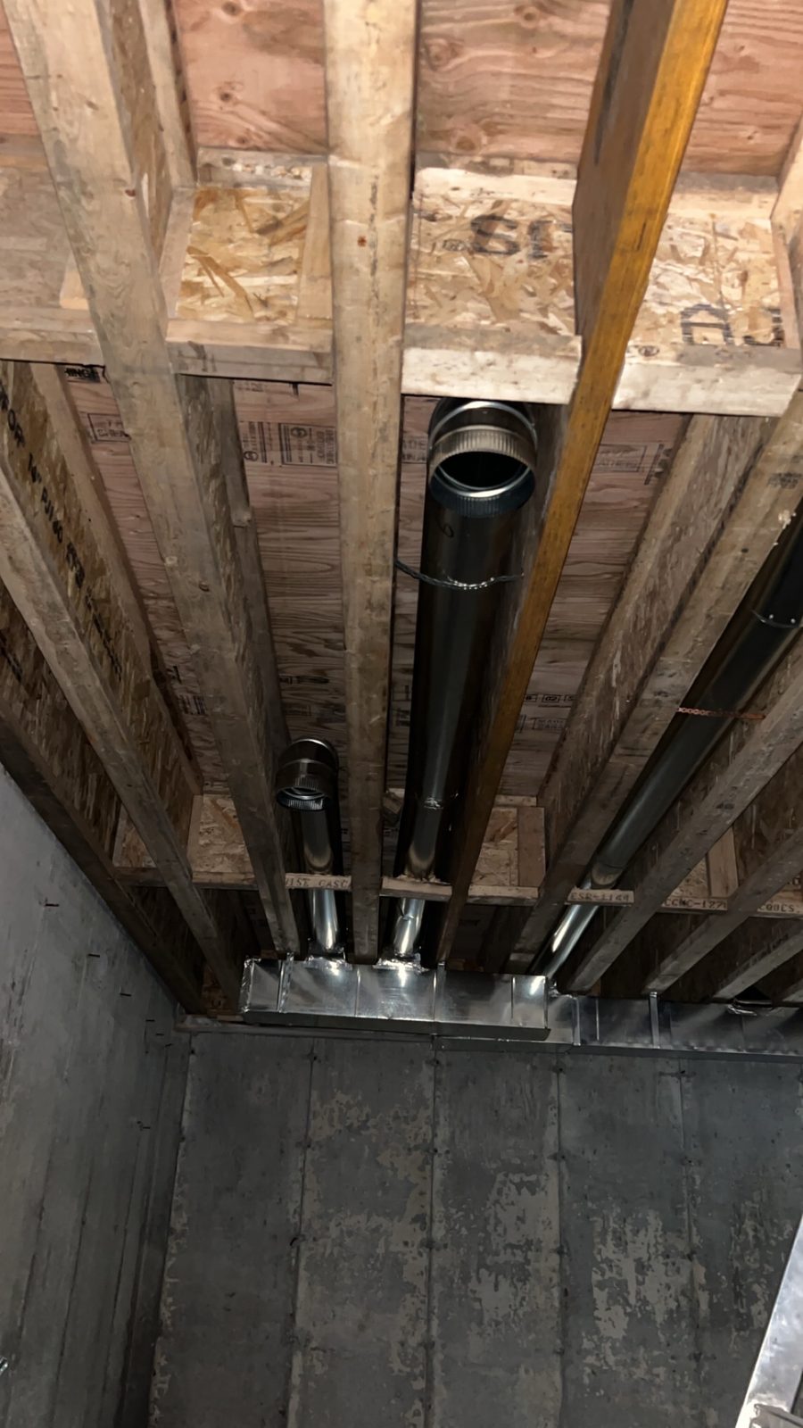 Custom sheet metal ductwork and venting run fabricated through basement floor joists
